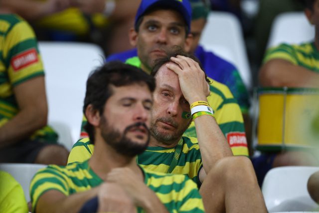 Smutní brazilští fanoušci po porážce ve čtvrtfinále | foto: Hannah McKay,  Reuters